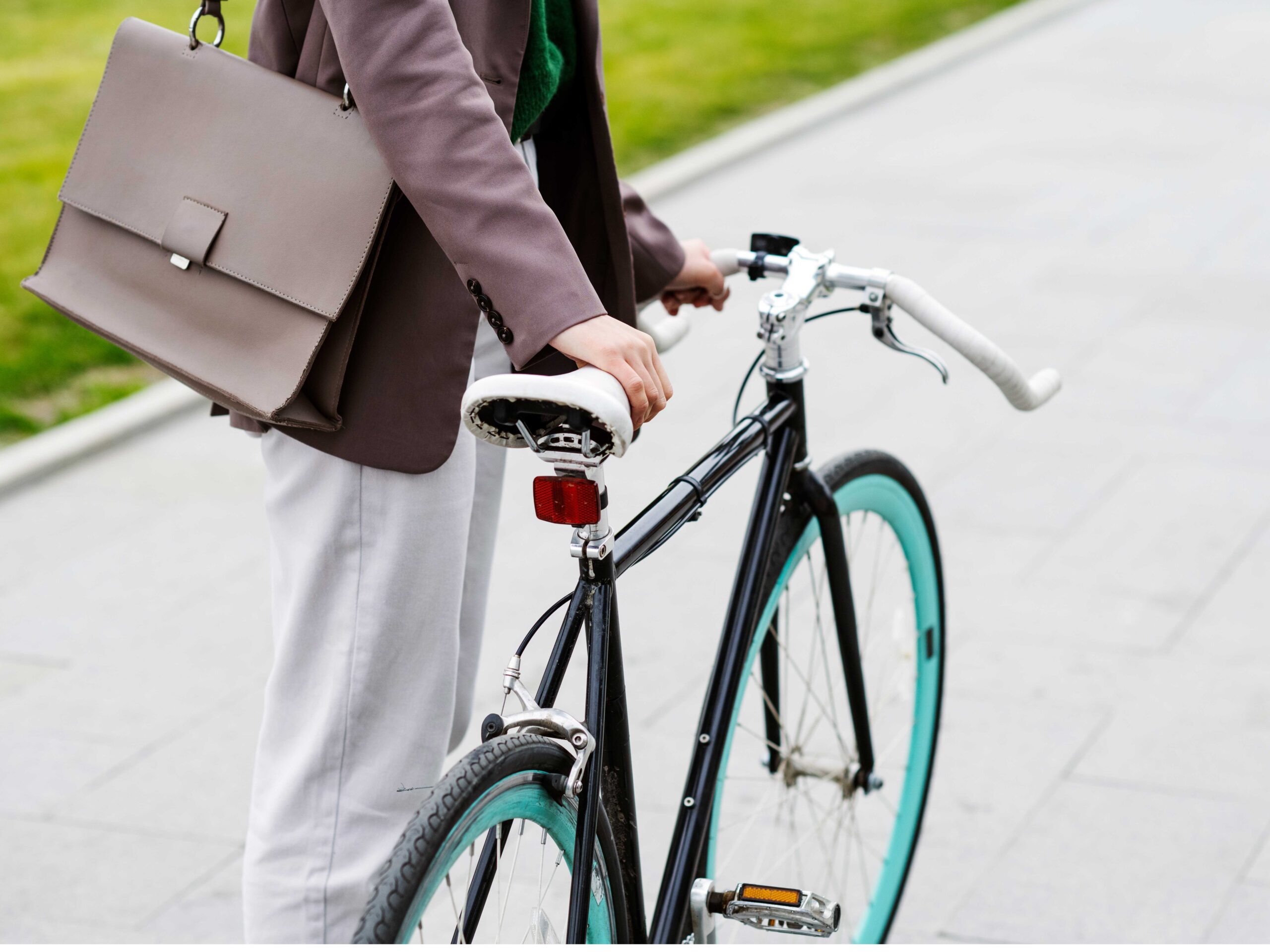 Mann mit Business-Tasche schiebt sein Fahrrad