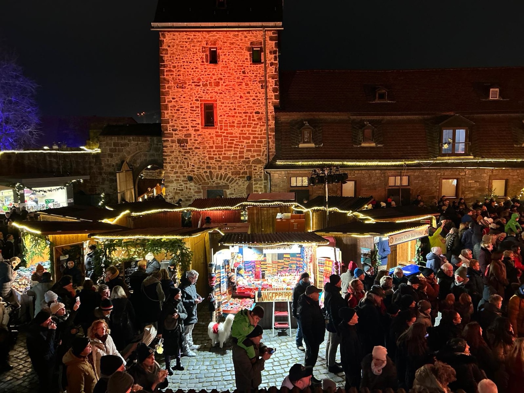 Weihnachtsmarkt in historischer Wasserburg mit Ständen und Menschen